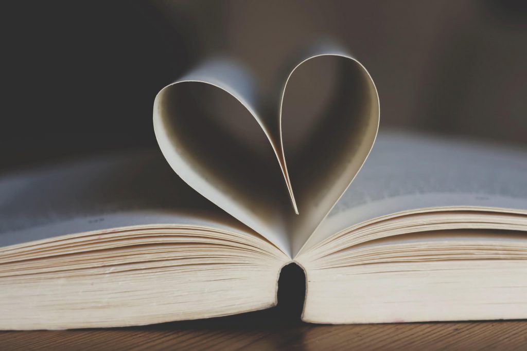 Open paperback publication with pages shaped like a heart