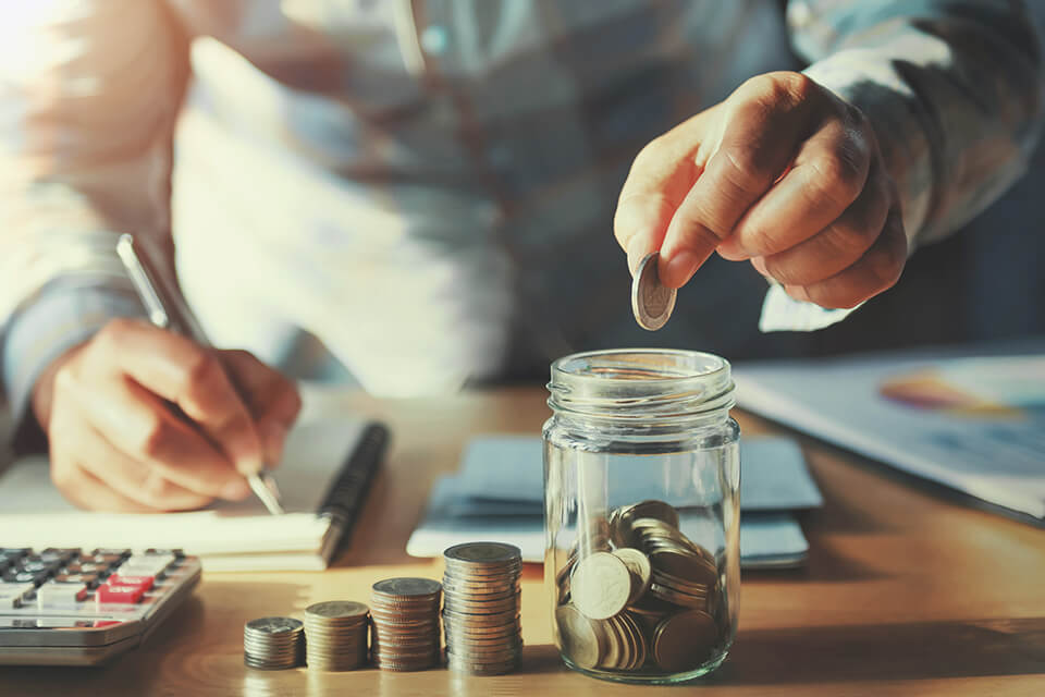 A man putting a coin in a jar