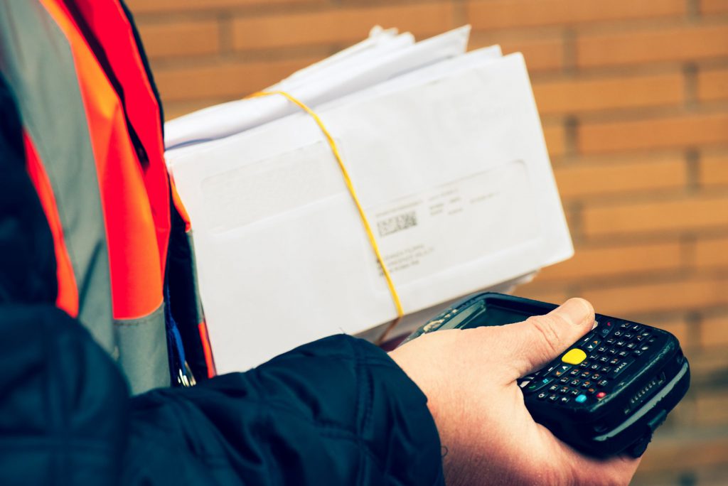 A postman holding a pile of envelopes