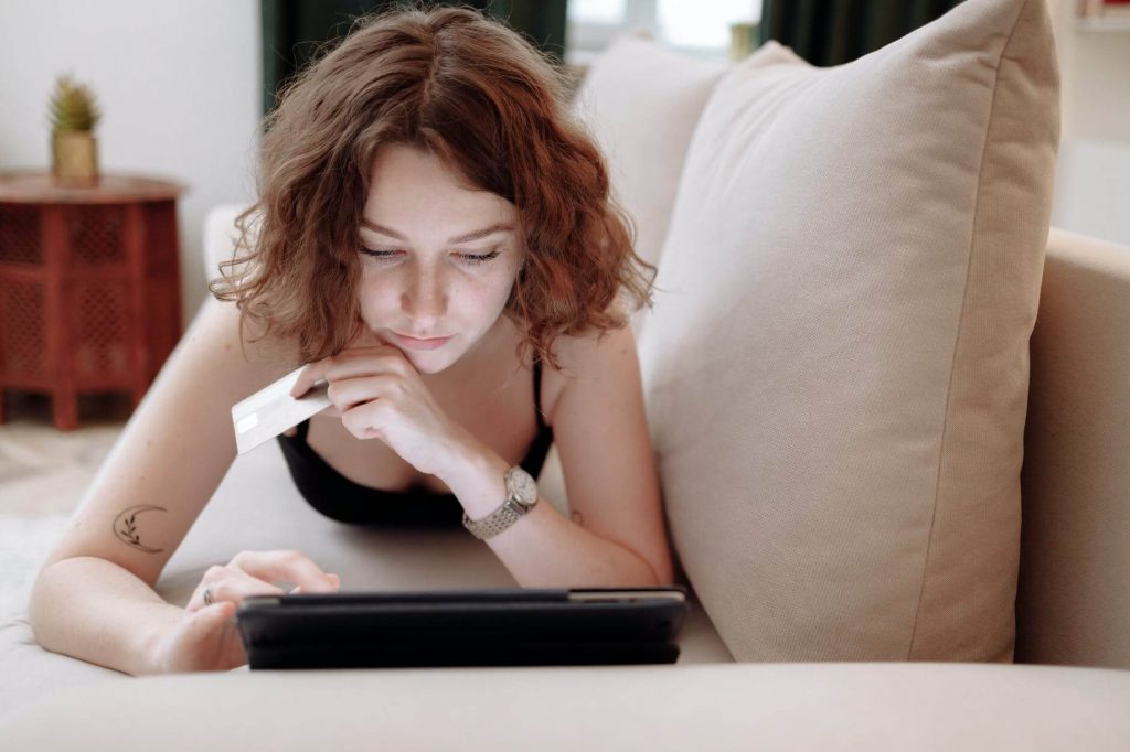 A woman with a credit card in front of her computer