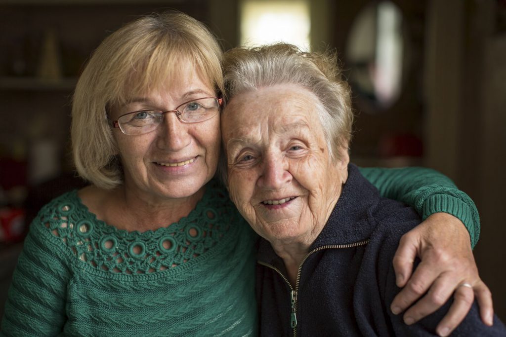 Two older ladies smiling because of the benefits of moving