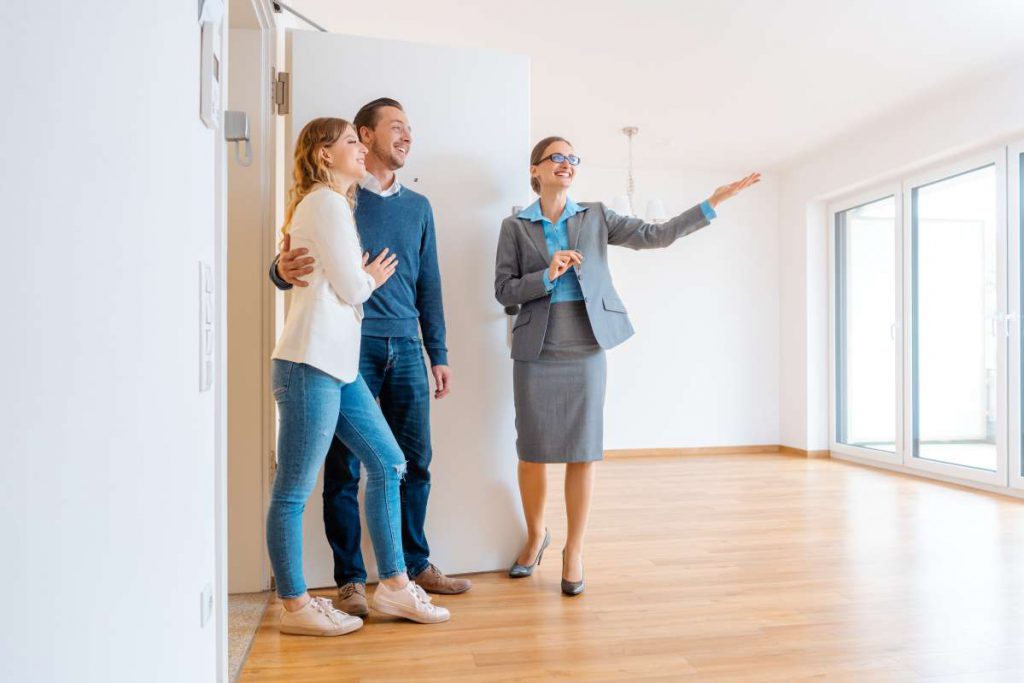 Three people looking at an apartment with a realtor