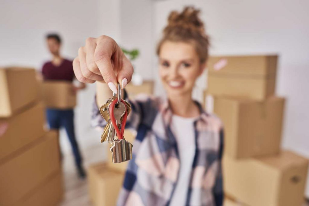 A girl holding keys from the home to which professional movers in Chicago will soon move her