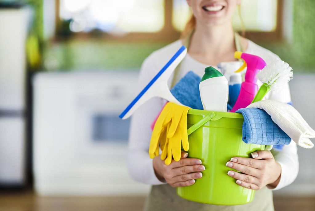 Person holding bucket with different supplies