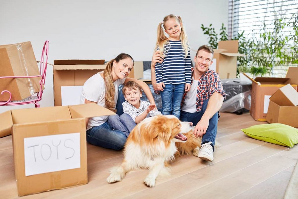 Man, woman, two kids, and a dog surrounded by packages before the move with professional movers in Chicago