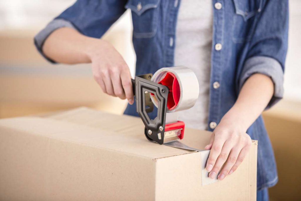 Person taping a carton before relocating with Chicago movers