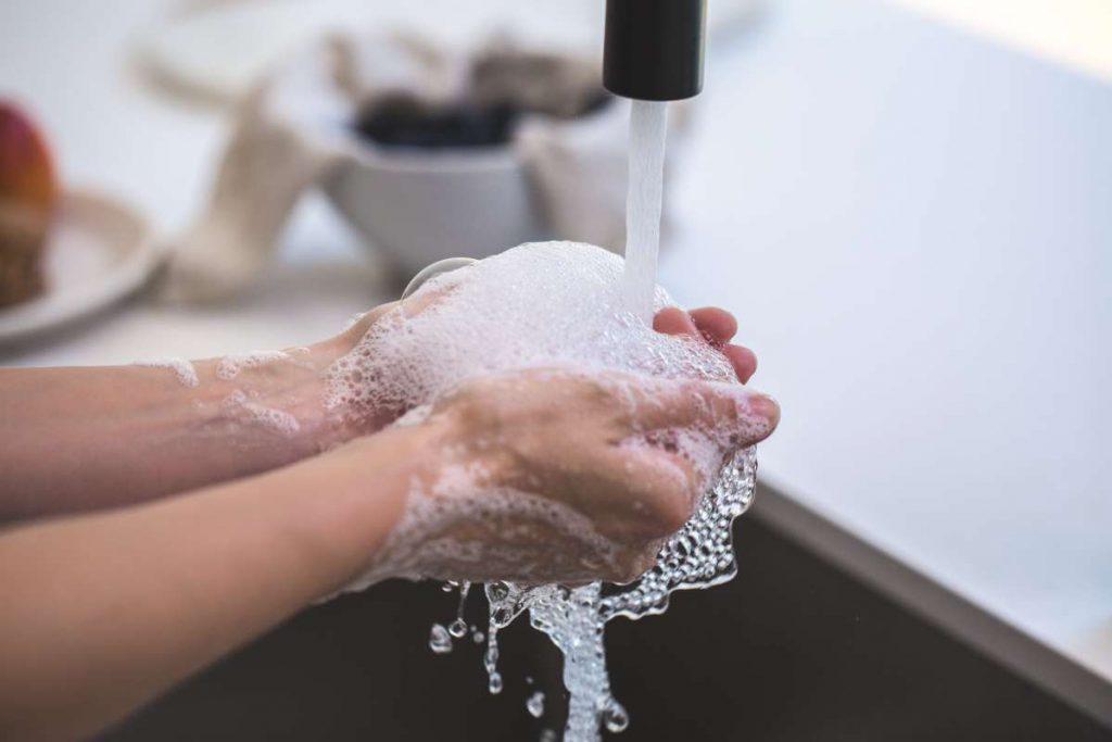 A person that learned how to clean an apartment before moving is scrubbing the sink