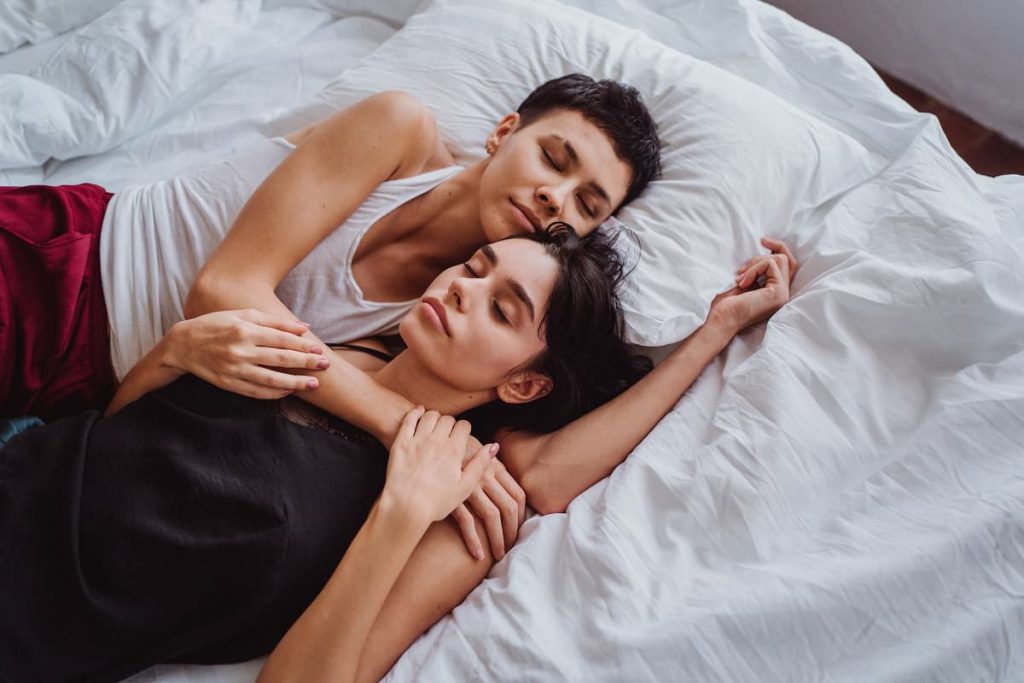 Two women laying in a bed