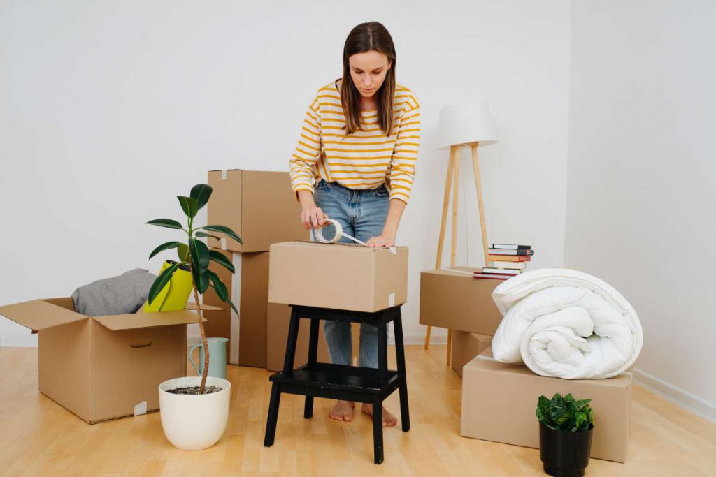 A girl preparing her furniture and living room objects for Chicago movers  
