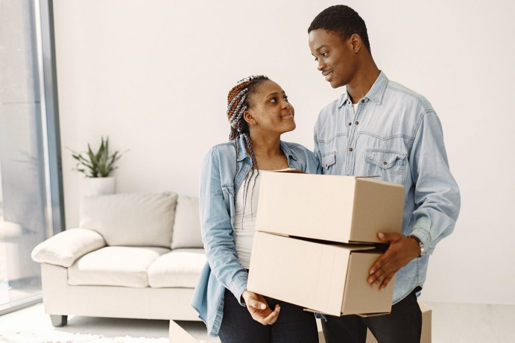 Couple bringing boxes inside the home