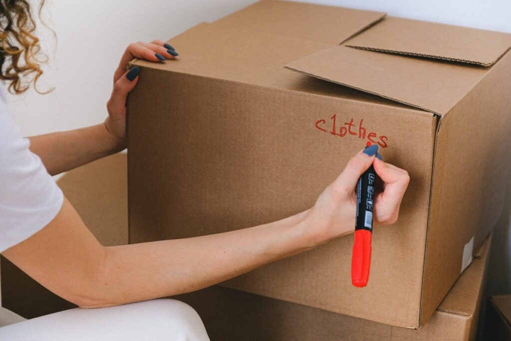 Woman writing label on a box