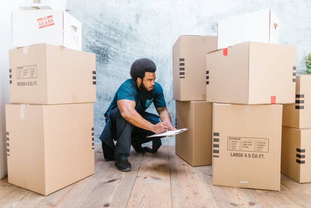 Professional apartment mover making moving boxes inventory